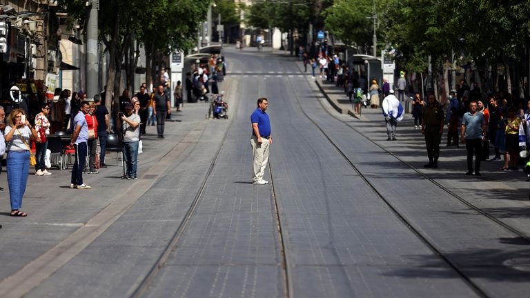 People stand still in Jerusalem as a two-minute siren sounds