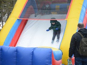 Kids brave flurries to take a slide down the bouncy castle at Homestead Market's Easter Eggstravaganza on April 9. A revised grant from the city aims to help out first-time events being organized within Airdrie.