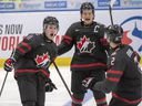 Canada's Alexis Lafreniere, left, celebrates with teammates Barrett Hayton and Kevin Bahl (2) at the 2020 world junior hockey championship.