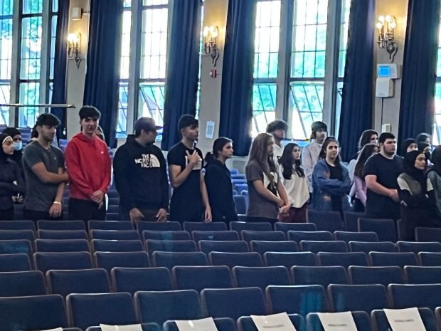 Students stand in auditorium