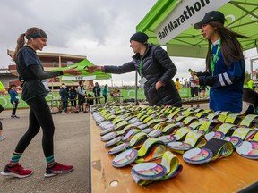 Calgary Centaur Subaru Half Marathon finishers receive medals on Sunday, May 29, 2022. The 6500 finisher medals for the various Calgary Marathon events arrived at the last minute at about 1 a.m. Sunday after been stranded on a container ship waiting in Vancouver harbour.