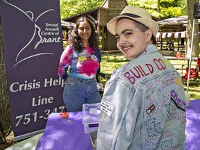 Mabe Kyle (right) of Brant County sports a message-laden jacket while chatting with Renu Dhaliwal of the Sexual Assault Centre of Brant at the Pride in the Park event at Mohawk Park on Saturday.