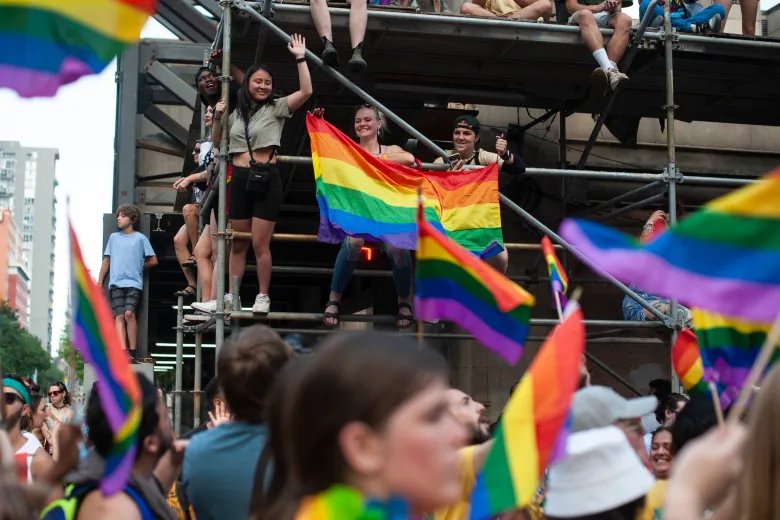 People watch as others march in the Pride parade, marking the return of in-person festivities for the annual LGBTQ celebration, in Toronto, Sunday, June 26, 2022. THE CANADIAN PRESS/Eduardo Lima