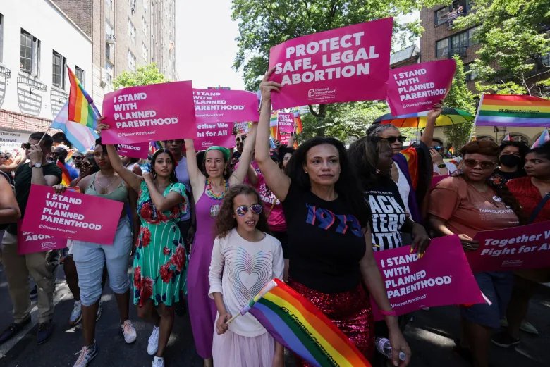 People hold posters during the 2022 NYC Pride parade in Manhattan, New York City, New York, U.S., June 26, 2022. REUTERS/Jeenah Moon