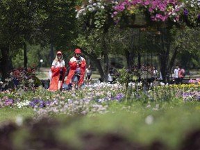 Danae Le Drew (L) and Destiny Kaus, who are draped in Canadian flags, walk through the Queen Elizabeth II Gardens during Canada Day celebrations at Wascana Park on July 1, 2022 in Regina.