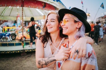 Smiling women in target shooting tent after reading their August 2022 monthly horoscope.