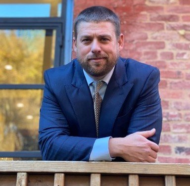 Photo of Joe Britton, executive director of ZETA, leaning on a balcony